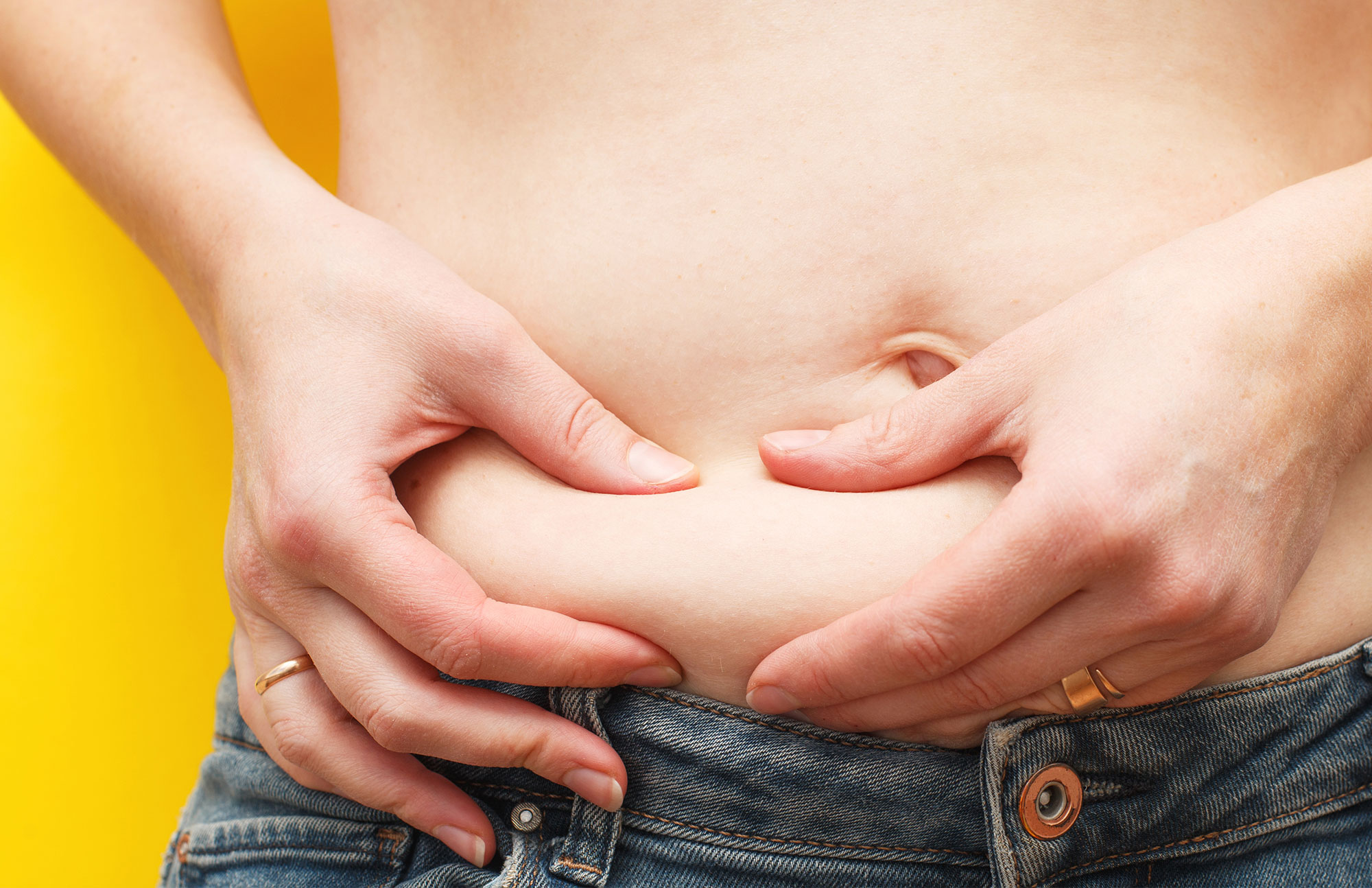 Person legt beide Hände auf den Bauch