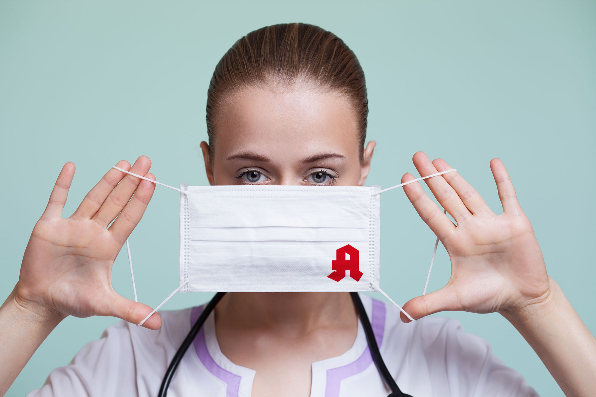 Frau mit einer Maske vor dem Gesicht auf der ein Apothekenlogo ist